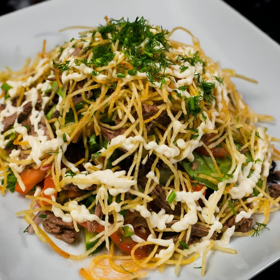 Halal salad with shredded beef, vegetables, crispy potato sticks, mayonnaise, and fresh dill.